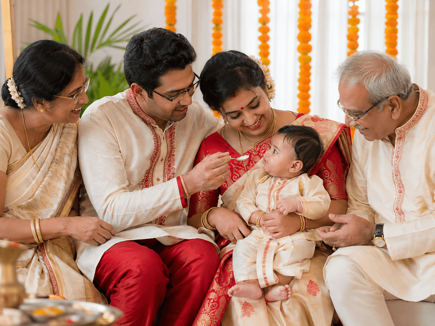 Illustrative rice ceremony scene with a baby and family